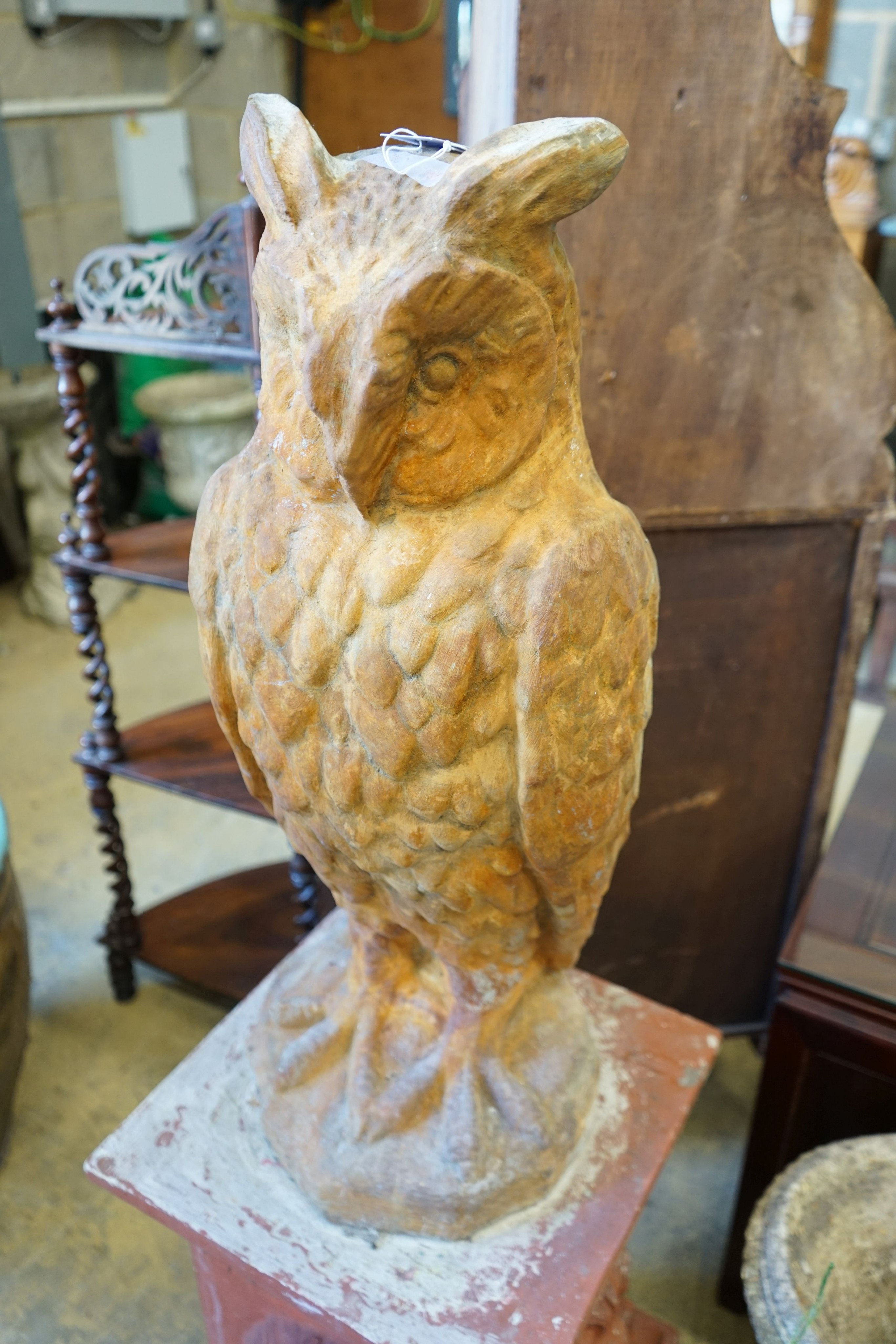 A reconstituted stone owl garden ornament on terracotta plinth, total height 130cm